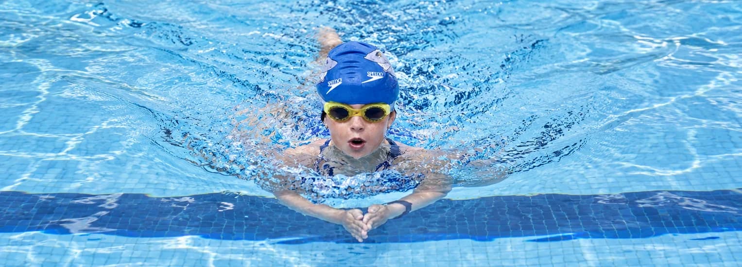 Enfant nageant la brasse dans le bassin